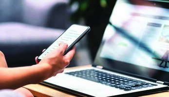 Person using phone and laptop