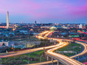 Washington DC skyline at dusk with traffic moving on highways in streams of lights 