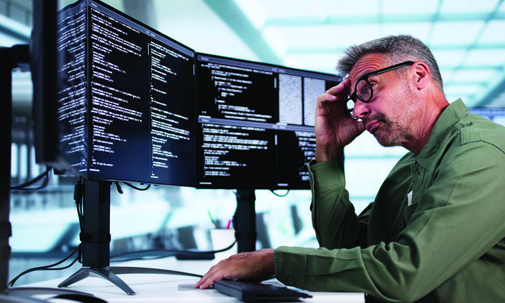 Man looking at coding on computer