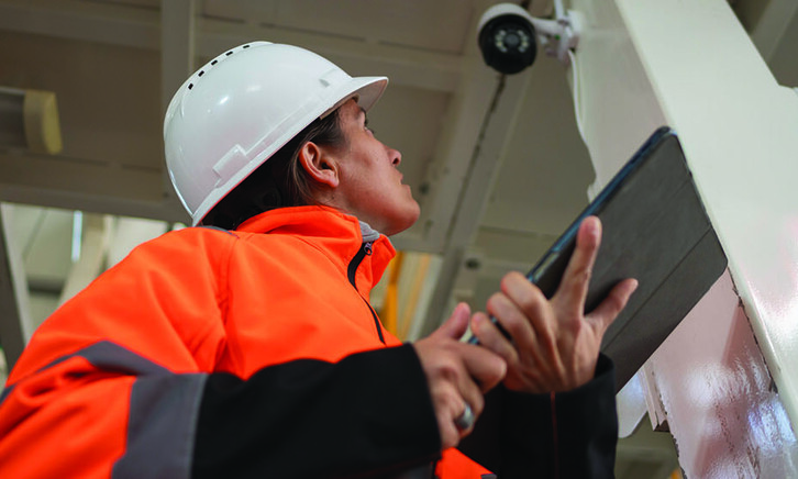 Factory worker inspecting camera