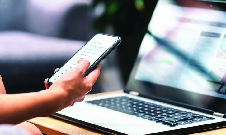 Person using phone and laptop