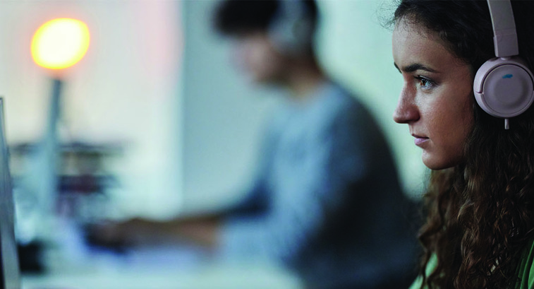 Woman at a monitor with headphones