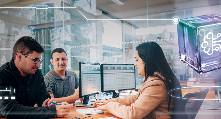 Three employees in front of a computer