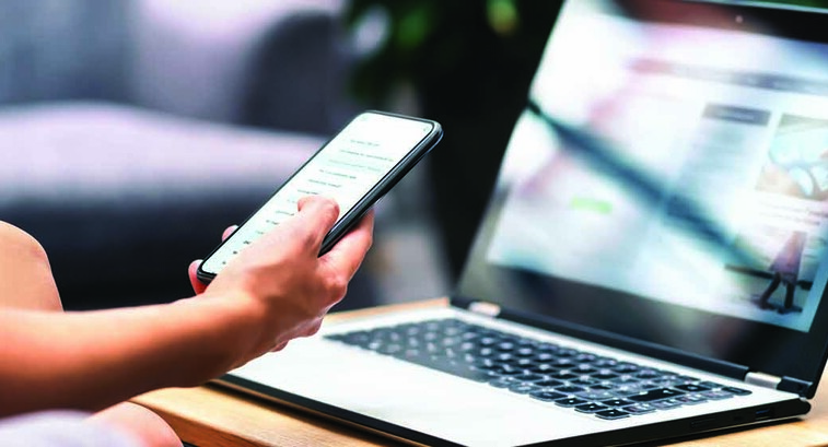 Person using phone and laptop