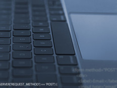 A software developer codes on a laptop