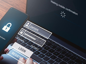 Person using smartphone to login waiting for scanner authentication on laptop.