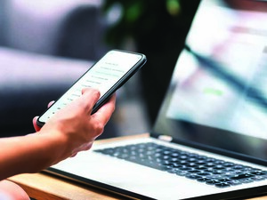 Person using phone and laptop