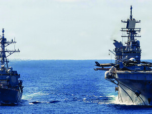 The USS Rafael Peralta (left) steams alongside the USS Tripoli