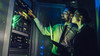 Man and woman checking cybersecurity sensor in a data center 