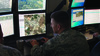 Uniformed Air National Guardsmen analyzing data at computer screens