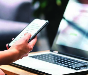 Person using phone and laptop